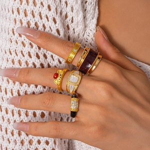 Detailed view of stacked vintage gold rings with purple enamel and diamond accents