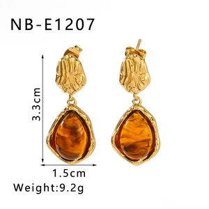 Detailed view of 18K gold plated textured earrings with amber resin oval pendants