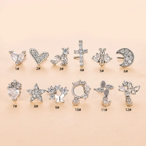 Twelve silver stainless steel nose studs with cubic zirconia in butterfly and cross shapes