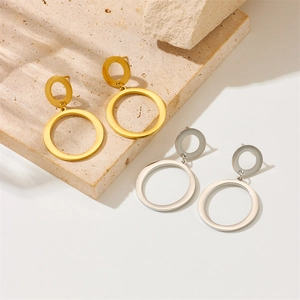 Minimalist double circle gold and silver stainless steel earrings on beige rock
