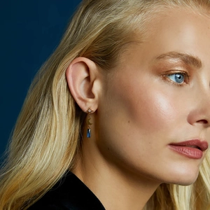 Detail of s925 silver star and moon earrings with blue crystal on a model side profile