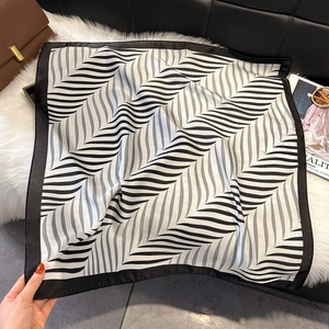Macro detail of silk-like square scarf with black and white geometric wave patterns