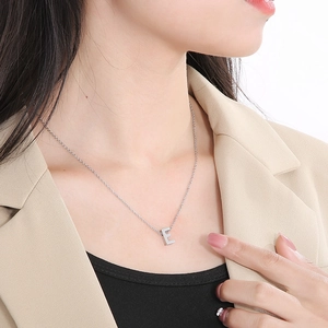 Elegant silver stainless steel necklace with a 3D letter E pendant worn on a female model