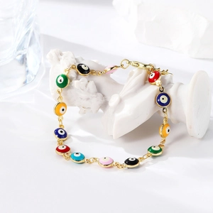 Detail of colorful enamel evil eye charms on a delicate gold plated link bracelet