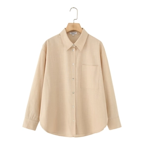Detailed fabric texture of a beige linen long sleeve collared shirt on a wooden hanger