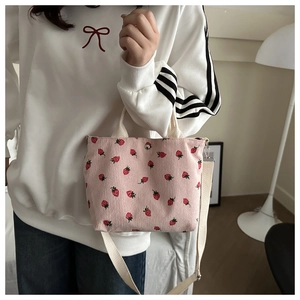 Pink corduroy mini tote bag with red strawberry pattern and white shoulder straps