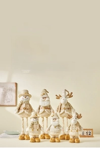 Detail of plush Christmas gnomes and reindeer figures in soft champagne gold and white tones