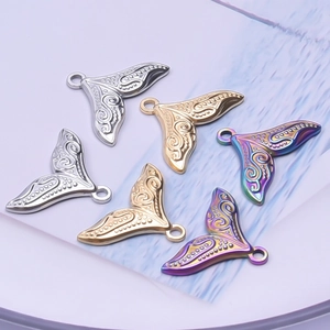 Macro shot of stainless steel fishtail charms in gold, silver, and rainbow finishes