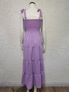 Detail of purple backless dress featuring layered tiered hem and bow shoulder straps