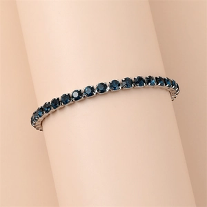 Detailed view of tennis bracelet featuring deep blue round-cut crystals in silver claw settings
