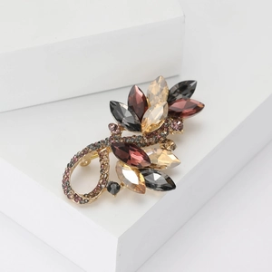 Elegant gold alloy brooch featuring amber and deep red crystals on geometric white blocks