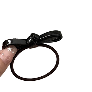 Elegant black bow hair tie featuring a glossy finish and durable elastic hair band