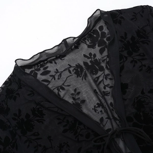 Detail of sheer black chiffon blouse featuring floral flocking and neckline ties
