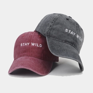 Washed cotton baseball caps in burgundy and charcoal grey with Stay Wild embroidery