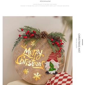 Festive wooden Merry Christmas sign with Santa gnome and greenery on a white chair