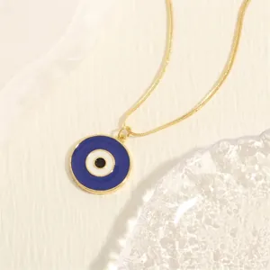 Detailed macro view of an 18K gold-plated snake chain with a blue Evil Eye enamel pendant
