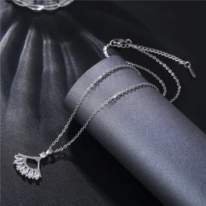 Detailed close-up of fan-shaped silver necklace with marquise zircons on velvet