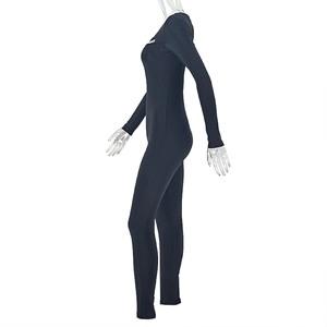Détail d'un body noir à manches longues avec découpe latérale et anneau métallique