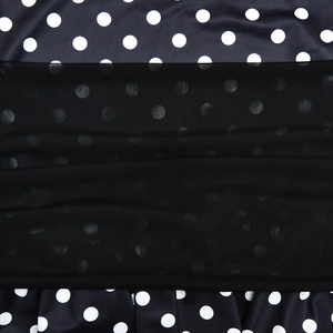 Macro shot of black fabric with white polka dots and delicate black mesh lace overlay