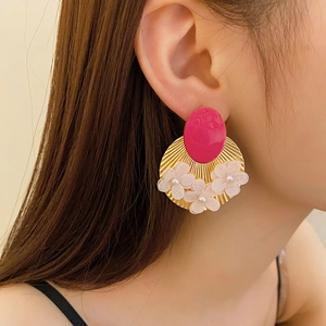 Detail of vintage butterfly earrings with pink resin, gold metal fan and fabric flowers