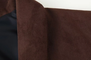 Detail of dark brown faux suede fabric showing soft texture and inner lining