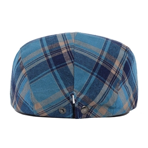 Detailed macro view of the vintage plaid cotton fabric and metal buckle on the flat cap
