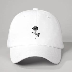 Close-up of a white baseball cap featuring detailed black rose floral embroidery