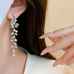 Detailed close-up of dangling leaf-shaped tassel earrings with sparkling rhinestones