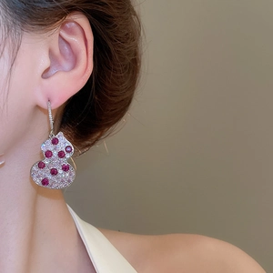 Close-up of zircon gourd hoop earring with red gemstones on a model's ear