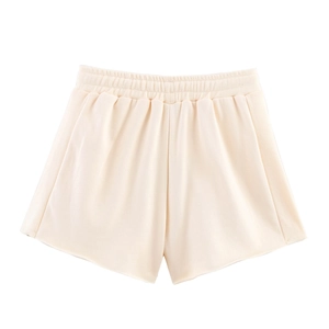 Dettaglio degli shorts in cotone crema a vita alta con fascia elastica e pannelli a coste