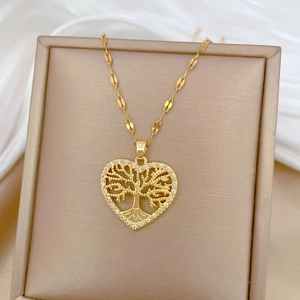 Gold heart necklace with Tree of Life pendant and crystals on a beige display box