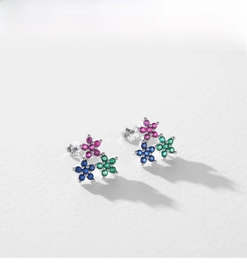 Macro detail of S925 silver flower earrings featuring colorful zircon stones in a trio cluster