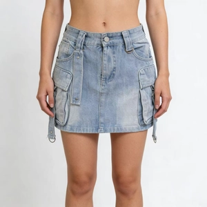 Detail of washed blue denim cargo skirt with large utility pockets and waist belt