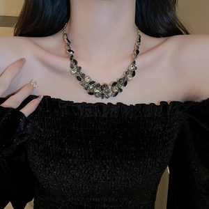 Detail view of vintage French necklace with black and dark green gemstone settings