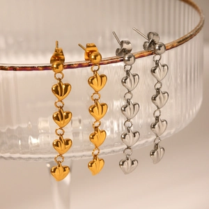 Vue macro de boucles d'oreilles pendantes en forme de cœur en finitions or et argent