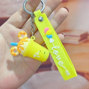 Close-up of bright yellow silicone milk tea cup keychain with love strap and metal ring