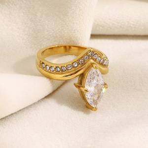 Dettaglio macro di un anello a corona in oro 18K con zircone marquise su tessuto