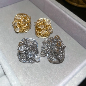 Detailed close-up of 18k gold and silver plated hollow square studs with crystals