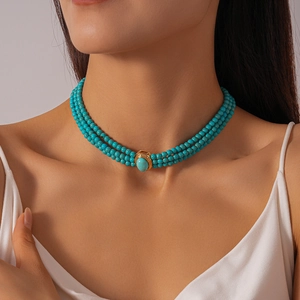 Detail of bohemian three-layer beaded choker with turquoise oval stone and golden edges