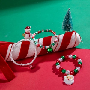 Detailed view of Christmas charm bracelets with red beads and Santa Claus pendants
