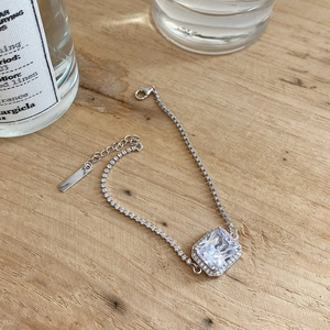 Minimalist 925 sterling silver bracelet with square zirconia stone on wood surface