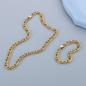 Detail of gold-plated Cuban link chain set featuring necklace and bracelet with twisted texture