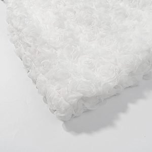 Close-up of white 3D rose textured fabric with layered floral embroidery detail