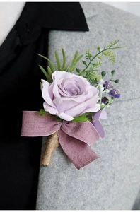 Detail of light purple silk rose boutonniere with dusty rose ribbon on tweed suit