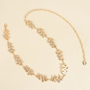 Detailed view of adjustable gold metal waist chain with wavy diamond pattern link design