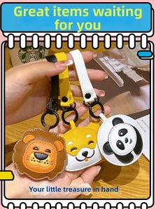 Close-up of handmade cartoon animal leather keychains with lion, dog and panda designs