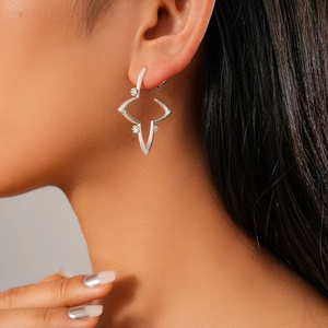 Detailed close-up of 18K gold plated starburst stud earring with zircon on model's ear