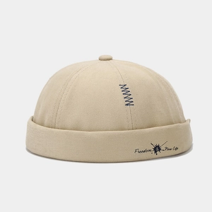 Detail of beige brimless docker hat with Freedom & New Life text and blue Z embroidery