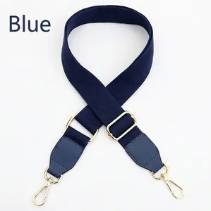Detail of adjustable blue canvas strap with gold metal buckles and leather finish
