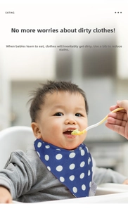 Close-up of baby eating in blue polka dot cotton bandana bib with snap button